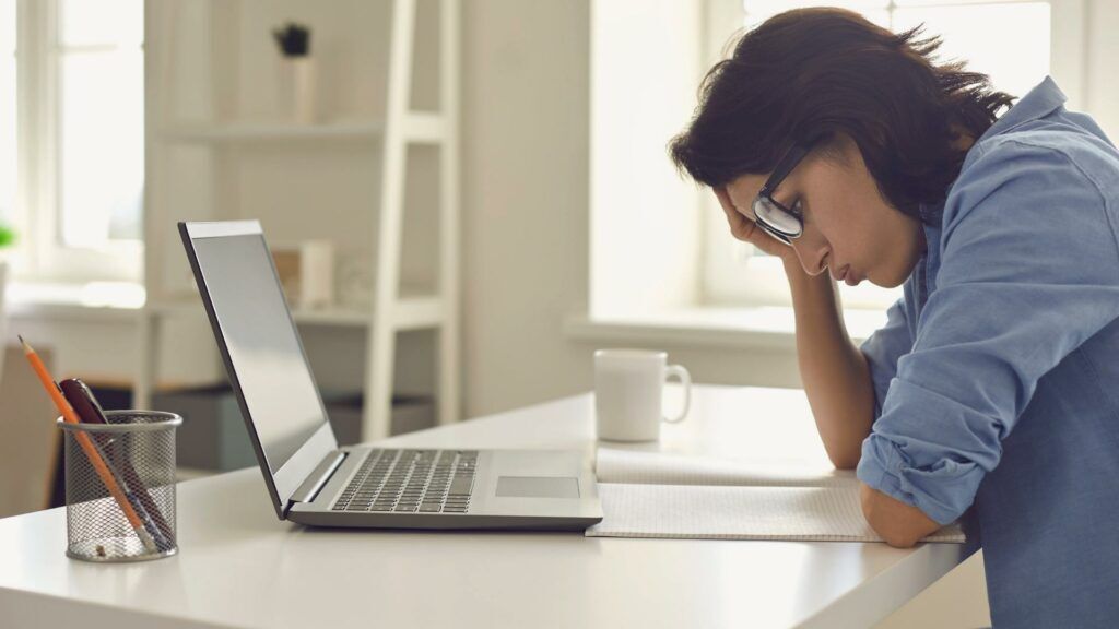 Stressed out SEO A person sits in front of their computer with a perplexed expression.